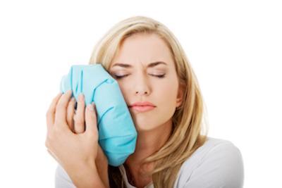 a woman holds an icepack up to her jaw | tmd treatment humble tx