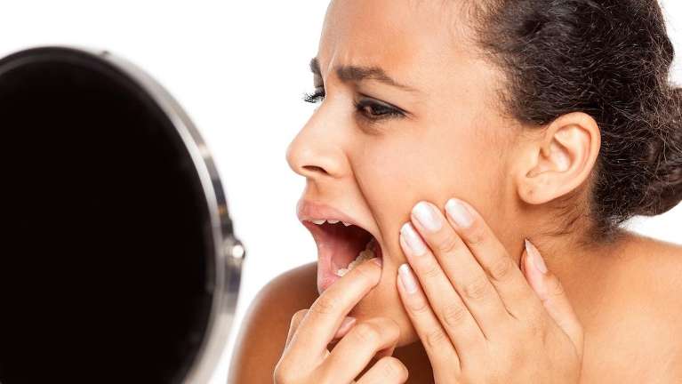 Woman in Humble TX checking her teeth in the mirror