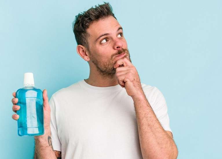 man holding a bottle of mouthwash in Humble, TX