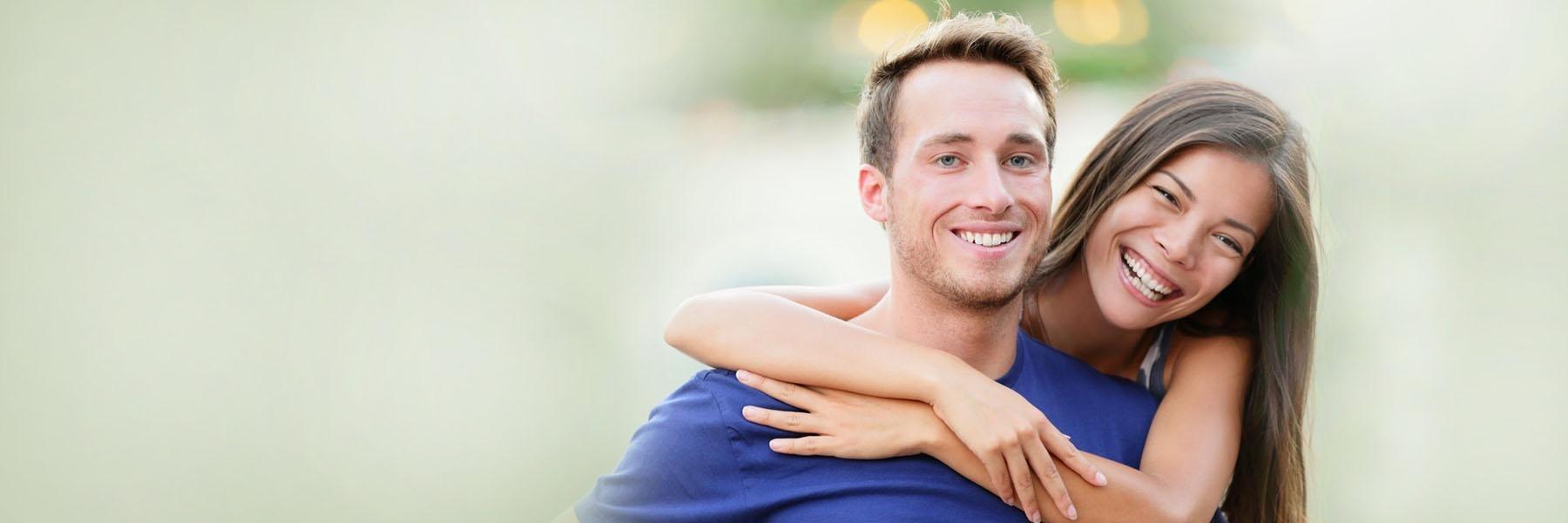 Young couple hugging outside l Emergency Dentist Humble TX